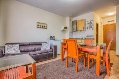 a living room with a table and chairs and a couch at Charming Flat in Bansko with Sauna by Flat Mаnager in Bansko