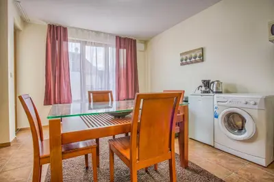 a dining room with a table and chairs and a washing machine at Charming Flat in Bansko with Sauna by Flat Mаnager in Bansko