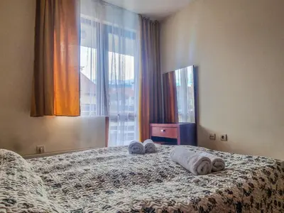 a bedroom with a bed with towels and a window at Charming Flat in Bansko with Sauna by Flat Mаnager in Bansko