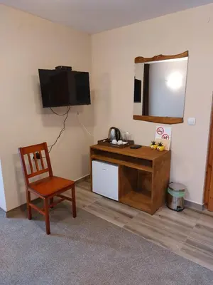 a room with a desk with a television and a chair at Къща за гости Бялото Конче in Beli Iskar