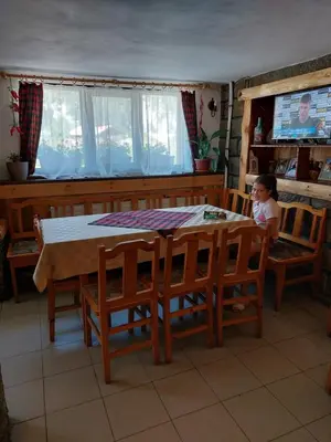 a little girl sitting at a dining room table at Къща за гости Бялото Конче in Beli Iskar