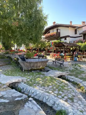 a park with benches and a fountain and a building at Snow Lodge Mountain view in Bansko
