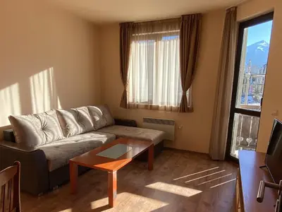 a living room with a couch and a coffee table at Snow Lodge Mountain view in Bansko