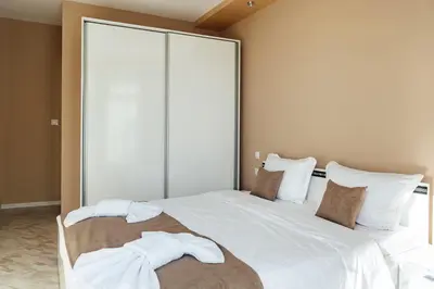 a bedroom with a large white bed with towels on it at Къща за гости Давиос in Sapareva Banya