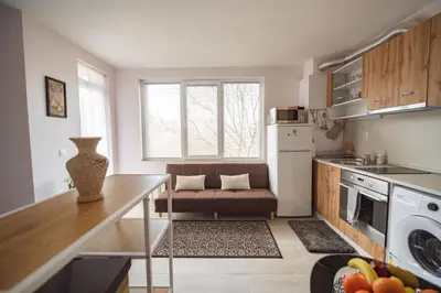 a kitchen with a table and a couch in a room at Paradise Guest Apartment in Sofia