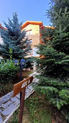 a street sign in front of a building with trees at Cozy studio with balcony and incl SPA in 4-star hotel Saint Ivan Rilski , Bansko in Bansko