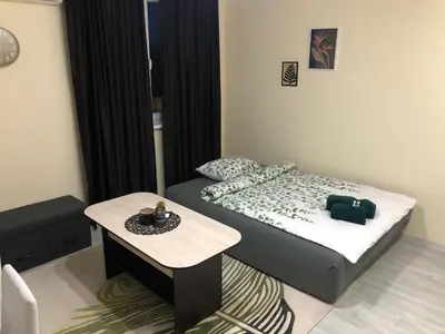 a small bedroom with a bed and a table at Superb apartment Free Underground Parking in Pazardzhik