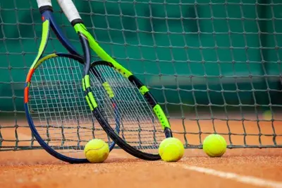 two tennis rackets and tennis balls on a court at Superb apartment Free Underground Parking in Pazardzhik