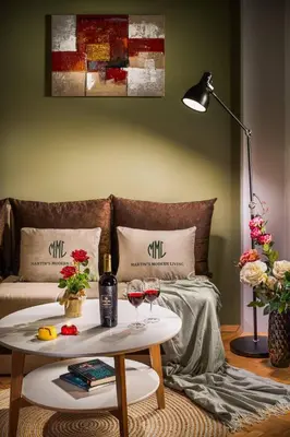 a living room with a bed and a table with wine glasses at Free Parking And Parliament Is 1 Step Away in Sofia
