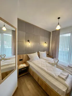 a bedroom with a large bed and a large mirror at СПА Хотел Романтика in Sarnitsa