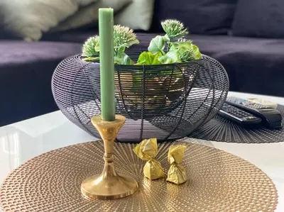 a candle on a table next to a vase at Lovely 1-bedroom apartament with free parking in Sofia