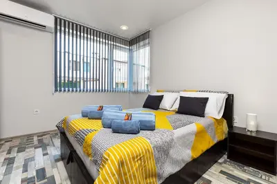 a bedroom with a bed with blue pillows on it at Florance flat next to Old Town & City Center NEW in Plovdiv