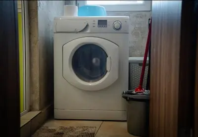 a washing machine in a room with a broom at Apart Centar in Plovdiv