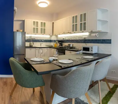 a kitchen with a table with chairs and a counter top at Sofia Apartment with Free Parking in Sofia
