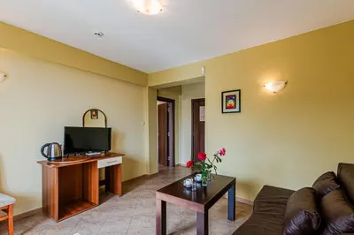 a living room with a couch and a tv at ArdoVel Park Hotel in Velingrad