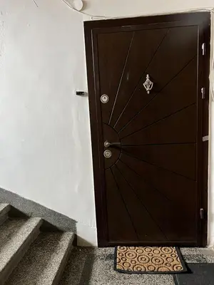 a brown door with a mat in front of a stairs at Vitosha 60 in Sofia