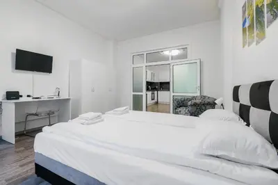 a white bedroom with a large bed and a desk at 2BD Citrus Apartment, Aristocratic Sofia Living by Flat Mаnager in Sofia