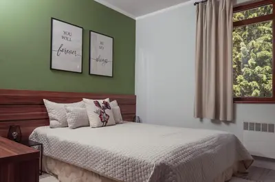 a bedroom with a bed with green walls and a window at Утро без Аларма, Смолянски езера. Alarm free Morning Smolyan lakes in Smolyan