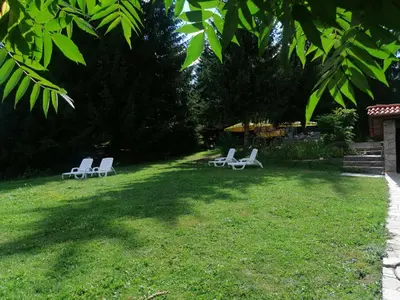 two white chairs sitting in the grass in a yard at Утро без Аларма, Смолянски езера. Alarm free Morning Smolyan lakes in Smolyan