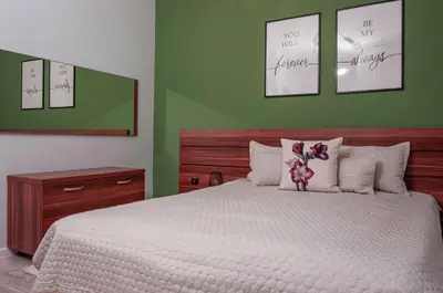 a bedroom with a large bed with four pictures on the wall at Утро без Аларма, Смолянски езера. Alarm free Morning Smolyan lakes in Smolyan