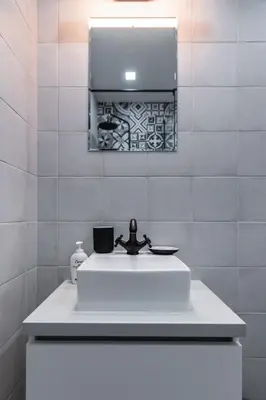 a bathroom with a white sink and a mirror at Charming Pastel 1BD Flat in The Heart of Sofia by Flat Mаnager in Sofia