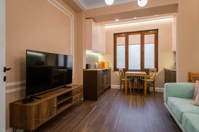 a living room with a flat screen tv and a couch at Charming Pastel 1BD Flat in The Heart of Sofia by Flat Mаnager in Sofia