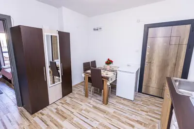 a dining room with a table and a kitchen at APARTEMENT VIVA in Sandanski