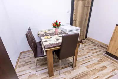 a dining room table with chairs and a vase of flowers on it at APARTEMENT VIVA in Sandanski