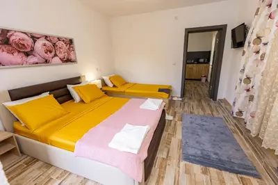 a bedroom with a large bed with yellow and pink pillows at APARTEMENT VIVA in Sandanski