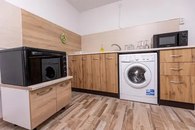 a kitchen with a washing machine and a microwave at Apartement Hérmitage in Sandanski