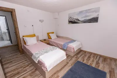 a room with two beds and a picture on the wall at Apartement Hérmitage in Sandanski