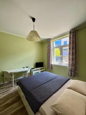 a bedroom with a bed and a desk and a window at Студио Top City Center in Plovdiv