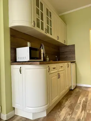 a kitchen with white cabinets and a microwave at Студио Top City Center in Plovdiv