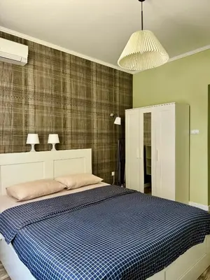 a bedroom with a large bed with a blue blanket at Студио Top City Center in Plovdiv