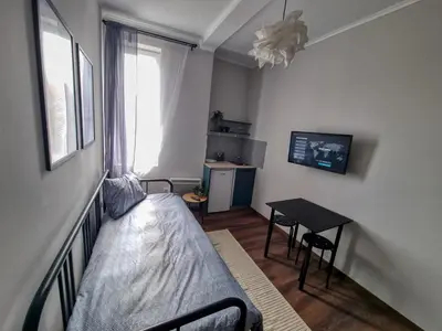 a small bedroom with a bed and a table at Cozy Studio in Center of Sofia in Sofia