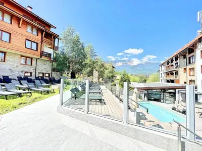 a resort with a pool and chairs and a building at St Ivan Rilski Free SPA Luxury Apartment Bansko in Bansko