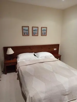 a bedroom with a bed and a table with a lamp at St Ivan Rilski Free SPA Luxury Apartment Bansko in Bansko