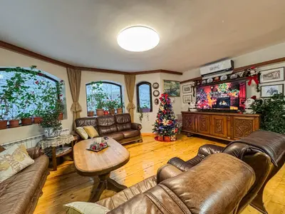 a living room with leather furniture and a christmas tree at Villa Janet in Dolna Banya