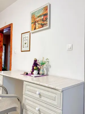 a white counter with flowers and a picture on the wall at Villa Janet in Dolna Banya
