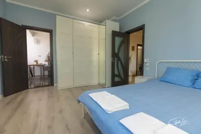 a large bedroom with a blue bed and a table at La Corte dei Bohem in Sofia