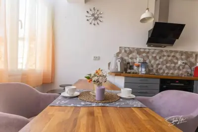 a table with two cups and a vase with flowers at La Corte dei Bohem in Sofia