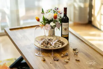 a bottle of wine and two glasses on a table at La Corte dei Bohem in Sofia