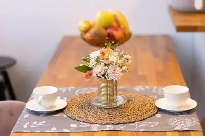 a vase of flowers on a table with two cups at La Corte dei Bohem in Sofia