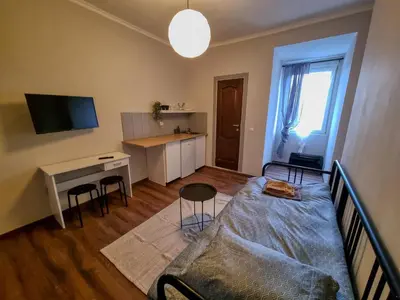 a bedroom with a bed and a desk with chairs at Welcoming Studio in Sofia Center in Sofia