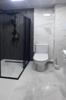 a white bathroom with a toilet and a shower at Zora in Blagoevgrad