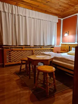 a bedroom with a bed and a table and stool at Астра къща за гости in Koprivshtitsa