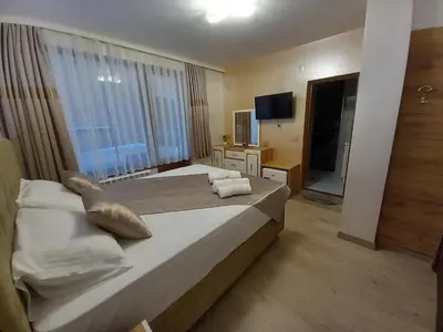 a bedroom with a large bed with towels on it at ЕЛЕГАНС къща за гости in Dospat