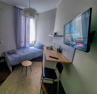 a small room with a bed and a desk with a television at Inviting Studio in Sofia Center in Sofia