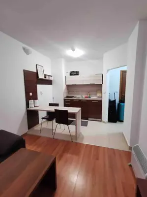 a living room with a table and a desk at Lovely private apartment in Belelvedre in Bansko