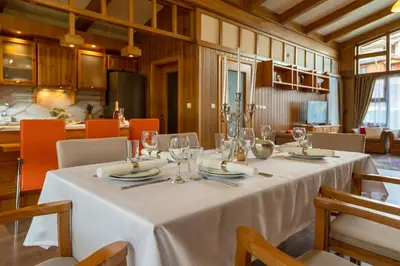 a dining room with a table with wine glasses at Boutique Holiday Pirin Golf in Razlog